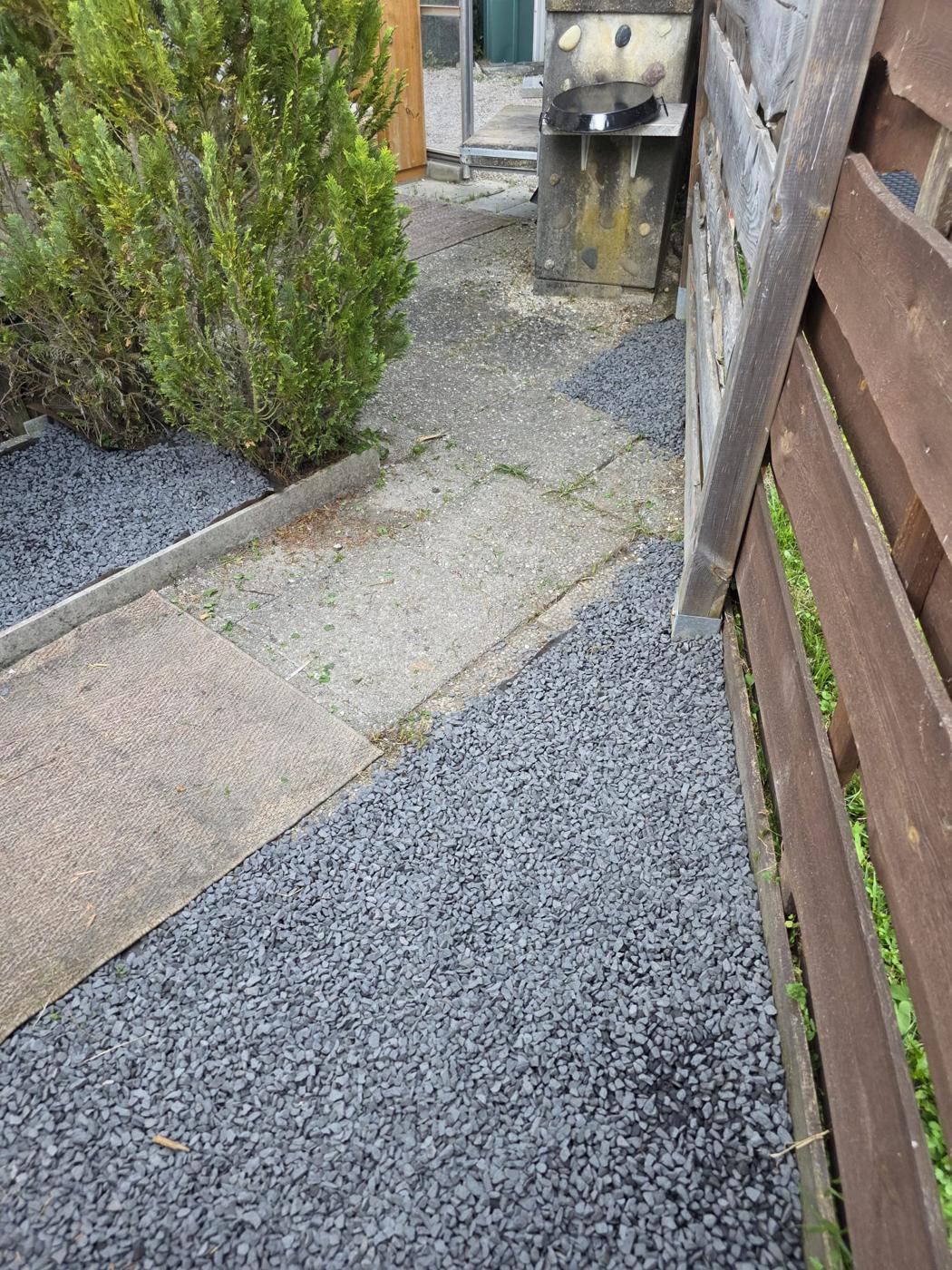 Allée de jardin entretenue avec gravier et haies taillées