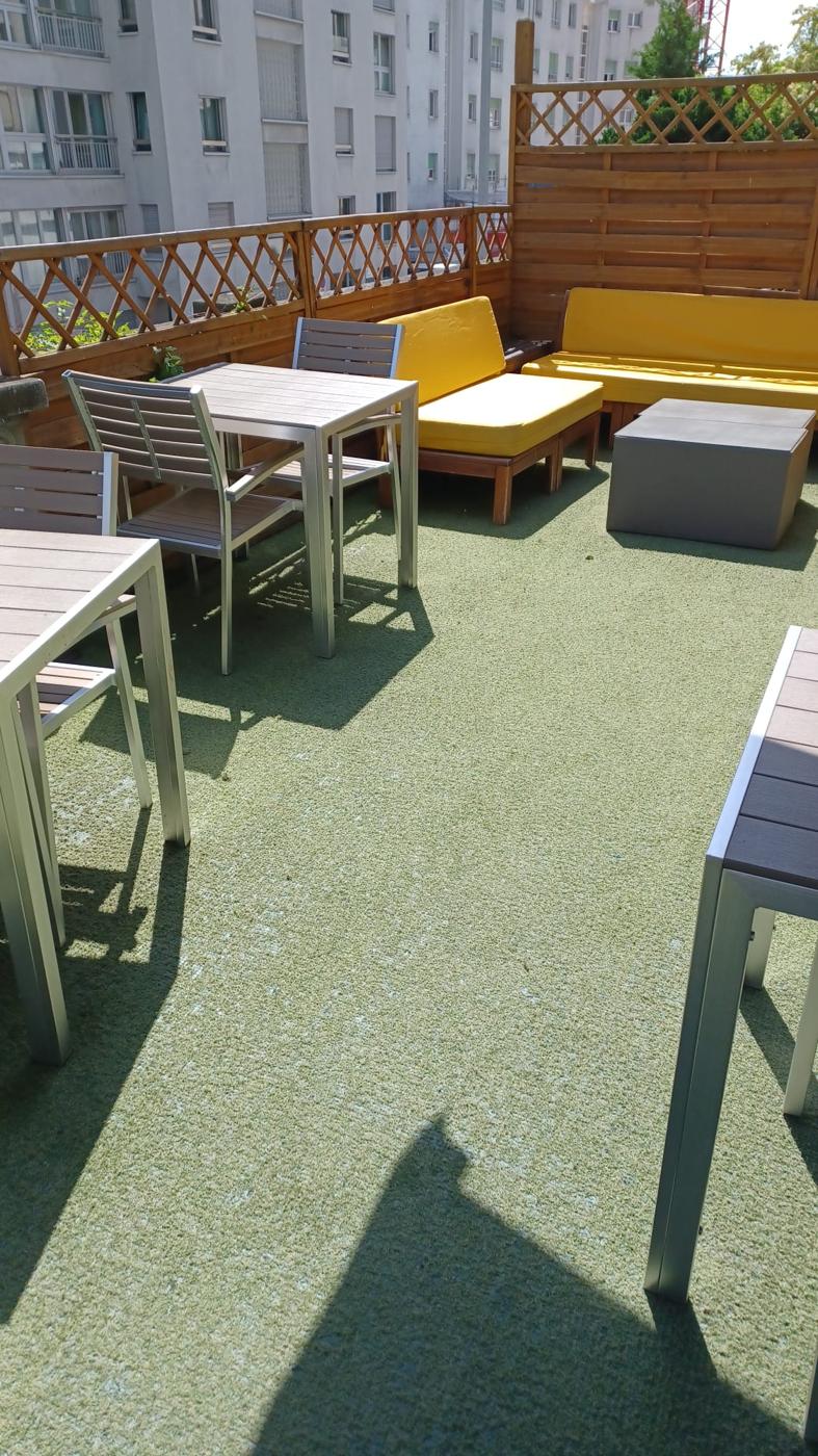 Terrasse extérieure de restaurant entretenue, mobilier et sol propres